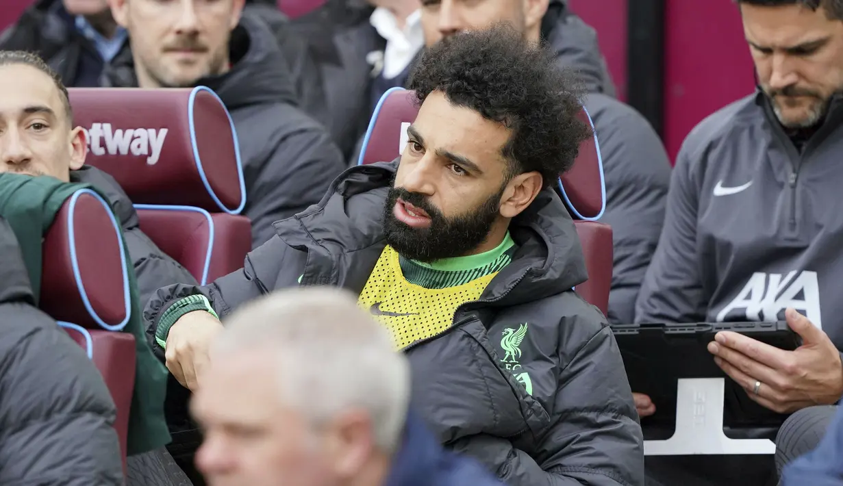 Striker Liverpool, Mohamed Salah duduk di bangku cadangan jelang dimulainya laga pekan ke-35 Premier League 2023/2024 menghadapi West Ham United di London Stadium, London, Sabtu (27/4/2024). (PA via AP Photo/Jonathan Brady)