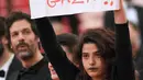 Aktris Manal Issa memegang poster bertuliskan "Hentikan Serangan di Gaza" saat menghadiri pemutaran film "Solo: A Star Wars Story" dalam Festival Film Cannes ke-71 di Cannes, Prancis (15/5). (AFP/Loic Venance)