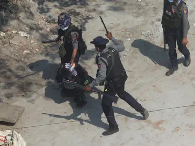 Petugas polisi anti huru hara menahan seorang pengunjuk rasa ketika mereka membubarkan demonstrasi di Kotapraja Tharkata di pinggiran Yangon, Myanmar, Sabtu (6/3/2021). PBB Myanmar mengecam tindakan kekerasan aparat terhadap pendemo dalam aksi damai menolak kudeta  militer. (AP Photo)