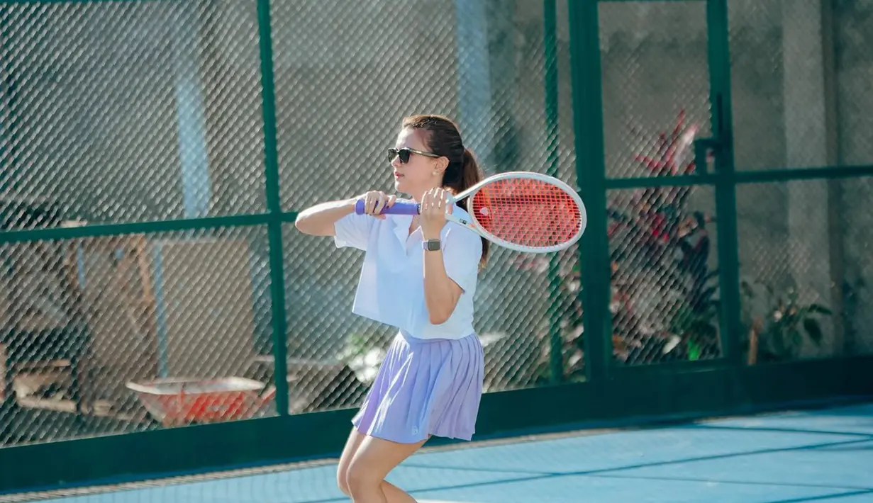 Begini potret Audi Marissa saat menjalani latihan tenis. Tampil dengan outfit olahraga yang stylish, penampilannya pun semakin keren dengan kacamata hitam dan rambut dikucir. Perpaduan outfit warna putih dan biru membuat penampilannya semakin terlihat cerah. (Liputan6.com/IG/@audimarissa)