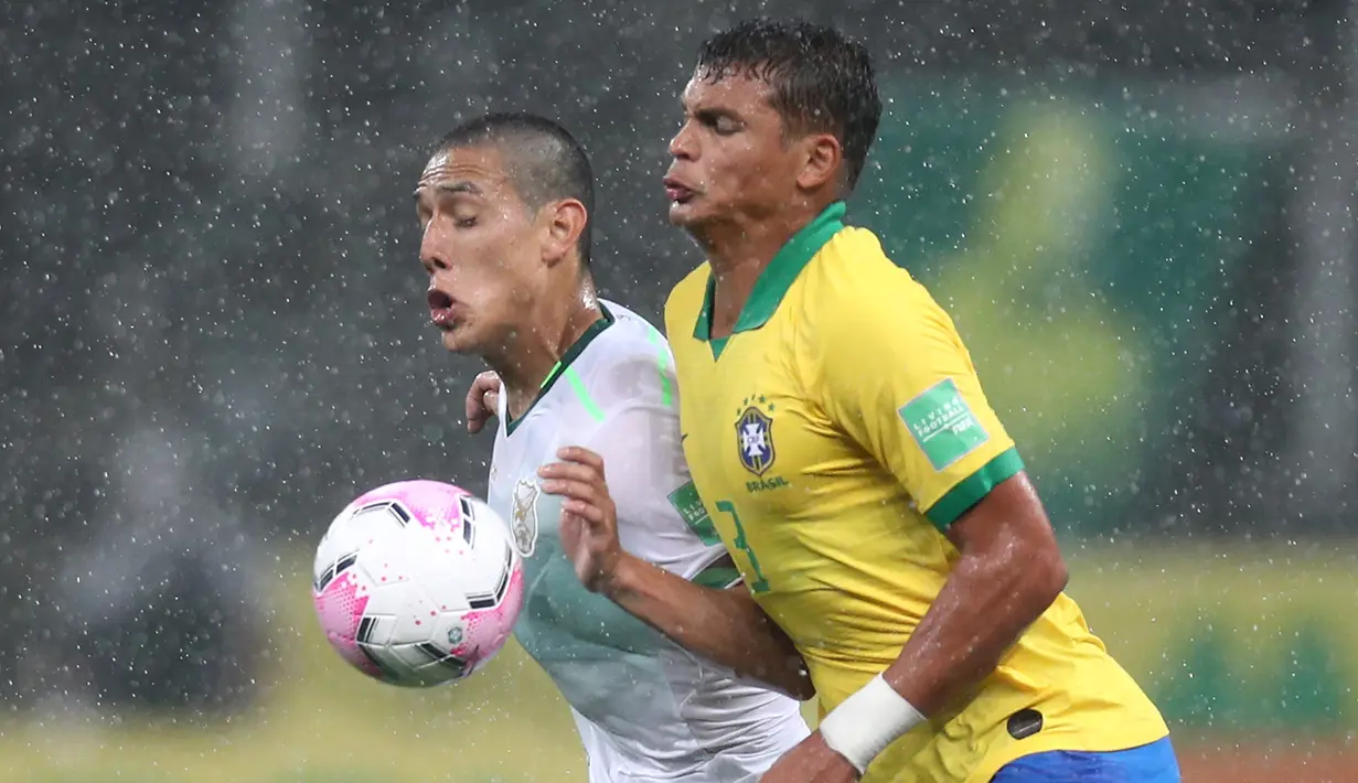 Bek Brasil, Thiago Silva, berebut bola dengan penyerang Bolivia, Cesar Menacho, pada laga kualifikasi Piala Dunia 2020 di Corinthians Arena, Sabtu (10/10/2020) pagi WIB. Brasil menang 5-0 atas Bolivia. (AFP/Buda Mendes/pool)
