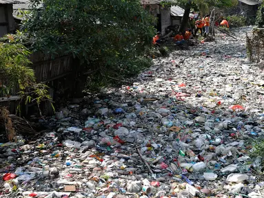 Petugas kebersihan membersihkan sampah di Kali Bahagia, Bekasi, Jawa Barat, Kamis (1/8/2019). Sampah di Kali Bahagia semakin menumpuk hingga menyerupai daratan. (AP Photo/Tatan Syuflana)