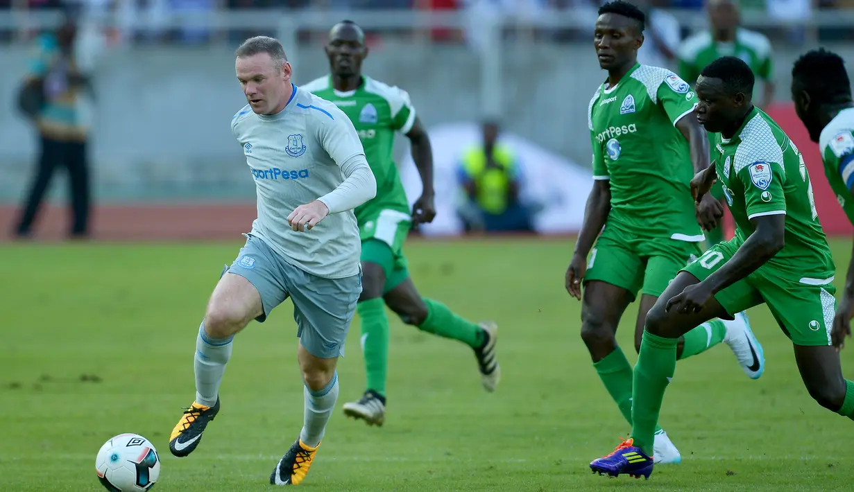 Striker Everton, Wayne Rooney (kanan) mencoba lolos dari kawalan pemain Gor Mahia pada pertandingan persahabatan di Tanzania, Kamis (13/7).  Rooney kembali tampil dalam seragam Everton setelah resmi meninggalkan Manchester United. (AP Photo/Khalfan Said)