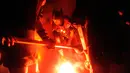 Anggota Jarl Squad menyalakan obor bersiap untuk membakar kapal perang Viking saat festival Up Helly Aa Viking di Lerwick, Kepulauan Shetland, Skotlandia (31/1). (Jane Barlow/PA via AP)