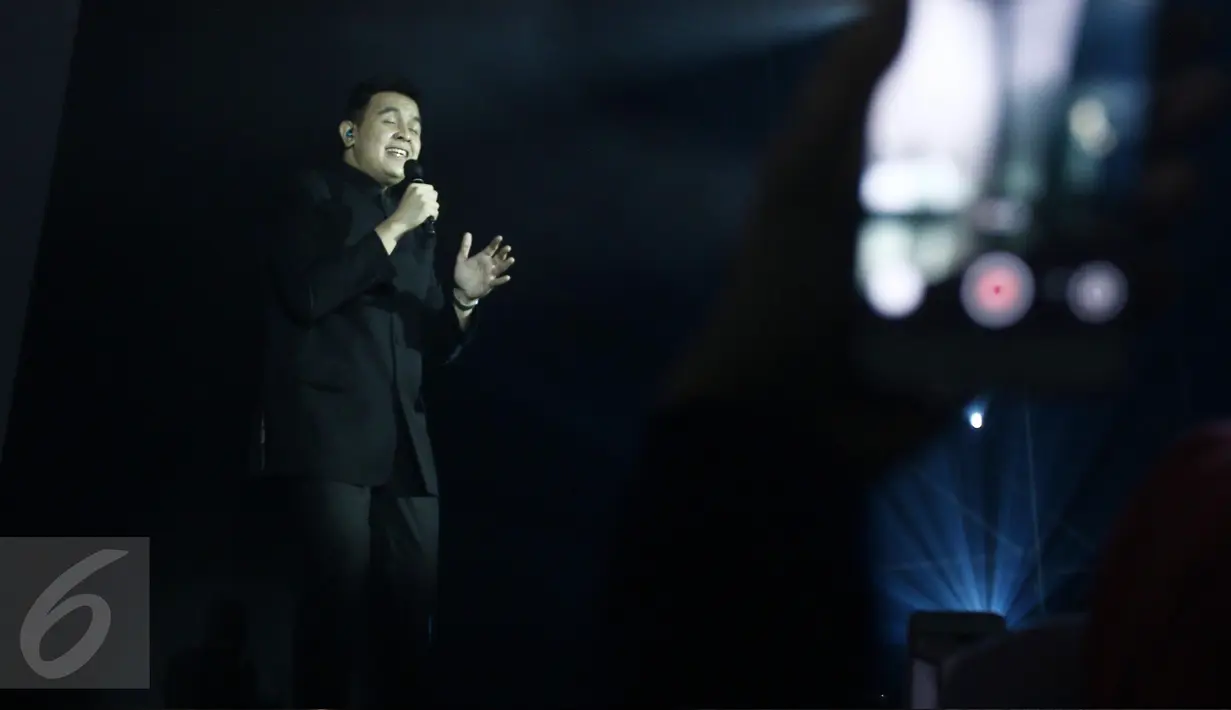 Penyanyi Tulus tampil dalam konser tunggal Rossa bertajuk 'The Journey of 21 Dazzling Years' di Plenary Hall, Jakarta Convention Center, Kamis (13/4). Tulus membawakan lagu Nada-Nada Cinta. (Liputan6.com/Herman Zakharia)