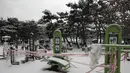 Perlengkapan fitness yang tertutup salju direkam untuk tindakan social distancing sebagai pencegahan terhadap virus corona di Goyang, Korea Selatan, Kamis (28/1/2021). (AP/Lee Jin-man)