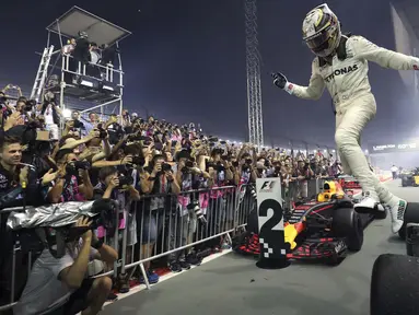 Pebalap Mercedes, Lewis Hamilton merayakan kemenangan saat menjuarai F1 Singapura di  Marina Bay City Circuit, (17/9/2017).  (AP/Yong Teck Lim)