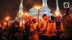 Anak-anak membawa obor sambil berkeliling kampung di kawasan Kota Tangerang, Banten, Jumat (29/7/2022) malam. Pawai obor tersebut digelar untuk menyambut malam pergantian Tahun Baru Islam atau 1 Muharam 1444 H. (Liputan6.com/Angga Yuniar)