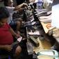Suasana saat perajin memproduksi sepatu di sebuah rumah industri di Jakarta, Selasa (6/3). OJK dan Menko Perekonomian memfokuskan kredit usaha rakyat (KUR) bagi UKM dengan sistem klaster. (Liputan6.com/Angga Yuniar)