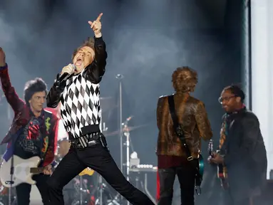 Penampilan Mick Jagger (tengah) saat konser Rolling Stones dalam tur 'No Filter' di Soldier Field, Chicago, Amerika Serikat, Jumat (21/6/2019). Jagger tampil memukau dengan aksinya yang energik di atas panggung. (Kamil Krzaczynski/AFP)