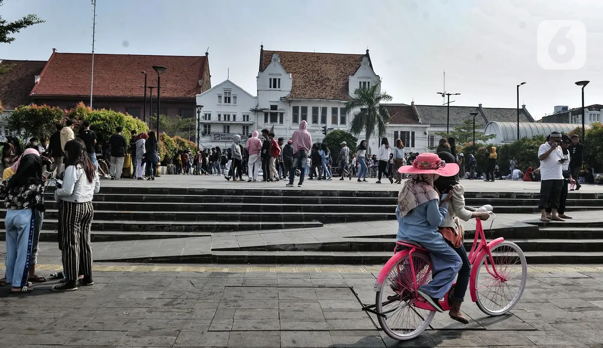 Wisatawan menaiki sepeda di kawasan wisata Kota Tua, Jakarta, Minggu (28/6/2020). Para pedagang, delman, dan jasa penyewaan sepeda pun terlihat kembali meramaikan suasana di sekitar Kali Besar. (merdeka.com/Iqbal S. Nugroho)