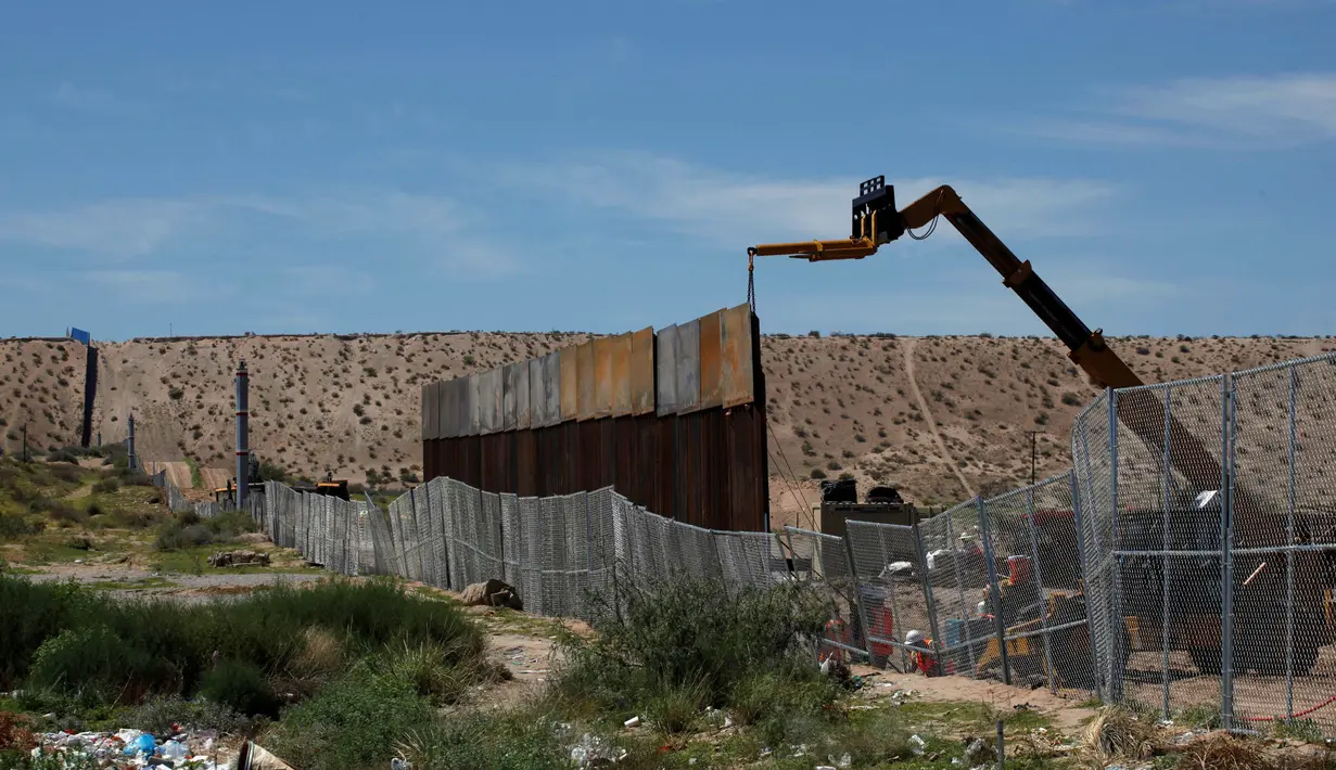Alat berat memasang pagar pembatas yang merupakan bagian dari dinding perbatasan AS-Meksiko di Sunland Park, AS (09/9). Capres AS, Donald Trump berjanji akan membangun tembok yang kuat untuk menggantikan sekat pembatas. (REUTERS/Jose Luis Gonzalez)