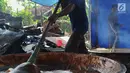Pekerja mengaduk adonan untuk membuat dodol Betawi di kawasan Studio Alam TVRI, Cilodong, Depok (31/5). Jelang Lebaran, dalam sehari tempat pembuatan ini dapat menghasilkan 400 kilogram dodol. (Merdeka.com/Arie Basuki)
