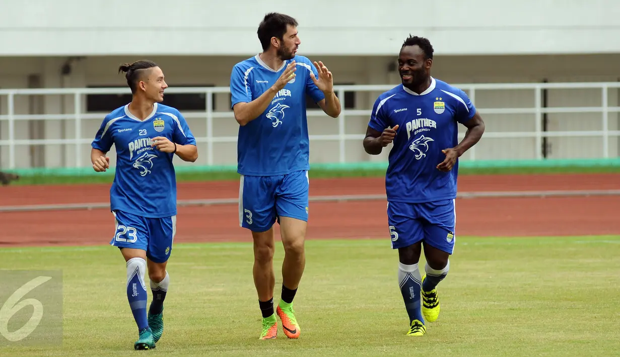 Bek Persib, Vladimir Vujovic (tengah) berbincang dengan Michael Essien saat latihan resmi jelang laga Liga 1 melawan PS TNI di Stadion Pakansari, Kab Bogor, Jumat (21/4). Laga kedua tim akan digelar pada Sabtu (22/4). (Liputan6.com/Helmi Fithriansyah)