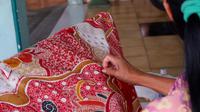 Perajin batik sedang membatik dengan teknik tulis pada Minggu (21/2/2021) di Kawasan Sentra Batik Laweyan Solo. (Liputan6.com/Laudia Tysara)