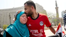 Pria asal Mesir, Mohammed Nufal (24) memeluk ibunya sebelum memulai perjalanan menuju Rusia menggunakan sepeda dari Tahrir Square di Kairo, Sabtu (7/4). Nufal nantinya akan mencapai Rusia melintasi tujuh negara di tiga benua selama 65 hari. (AP/Amr Nabil)