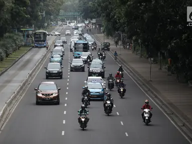 Pengendara sepeda motor melintasi Jalan MH Thamrin-Medan Merdeka Barat, Jakarta Pusat, Kamis (11/1). Peraturan larangan motor melintas di Jalan MH Thamrin pada jam-jam tertentu telah resmi dicabut. (Liputan6.com/Arya Manggala)