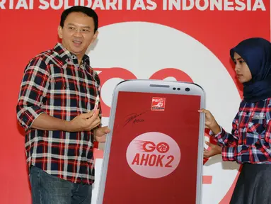  Calon Gubernur DKI Basuki Tjahaja Purnama (tengah) usai menandatangani replika aplikasi Go Ahok2 saat diluncurkan di Jakarta, Senin (28/11). Aplikasi ini untuk memudahkan arus informasi Cagub dan Cawagub Ahok-Djarot. (Liputan6.com/Helmi Fithriansyah)