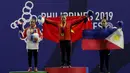 Lifter Lisa Setiawati (kiri) saat naik podium usai mendapatkan medali perak SEA Games 2019 cabang angkat besi nomor 45 kg di Stadion Rizal Memorial, Manila, Minggu (1/12). Dirinya meraih perak dengan total angkatan 169 kg. (Bola.com/M Iqbal Ichsan)