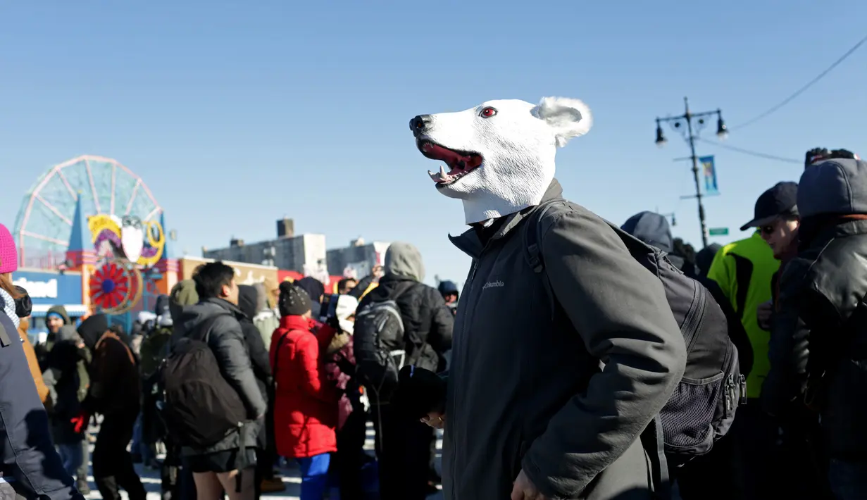 Seorang peserta mengenakan topeng saat menghadiri acara renang Polar Bear Club di Coney Island, New York (1/1). Dalam acara tersebut, para peserta diwajibkan untuk berenang di air yang dingin. (Yana Paskova/Getty Images/AFP)