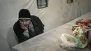 Borya, 58, yang dievakuasi dari kota Baryshivka oleh pemerintah Ukraina karena pertempuran sengit, menunggu di dalam tenda setelah tiba di Brovary, di pinggiran Kiev, Ukraina, Selasa, 29 Maret 2022. (AP Photo/Rodrigo Abd)