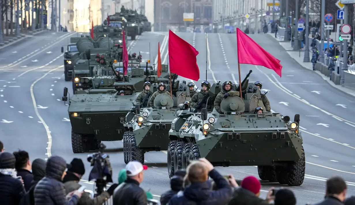 <p>Penonton menyaksikan kendaraan lapis baja Rusia yang dihiasi bendera merah di sepanjang jalan Tverskaya menuju Lapangan Merah untuk menghadiri latihan parade militer Hari Kemenangan di Moskow, Rusia, Rabu (4/5/2022). Pawai akan berlangsung pada Mei 9 untuk merayakan 77 tahun kemenangan dalam Perang Dunia II. (Foto AP/Alexander Zemlanichenko)</p>