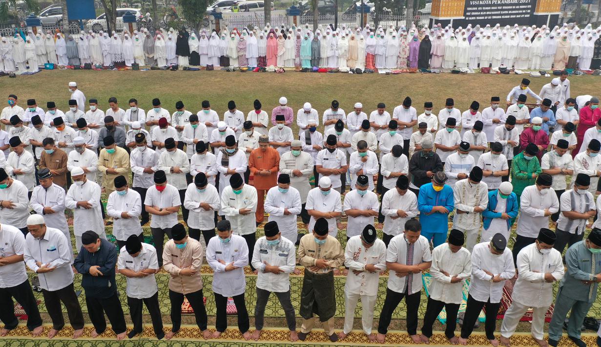Foto dari udara memperlihatkan umat muslim melaksanakan salat minta hujan (Istisqa) saat kabut asap menyelimuti kota Pekanbaru, di Riau, Jumat (13/9/2019). (ADEK BERRY / AFP)
