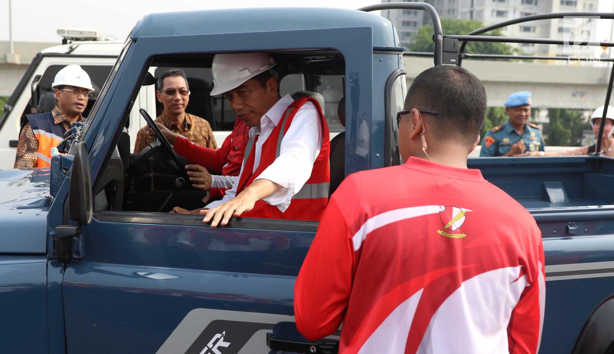 Presiden Joko Widodo (Jokowi) menaiki mobil jip seusai meresmikan jalan Tol Bekasi-Cawang-Kampung Melayu (Becakayu), Jumat (3/11). Bersama rombongan, Jokowi konvoi menjajal ruas tol sepanjang 8,26 km itu. (Liputan6.com/Angga Yuniar)