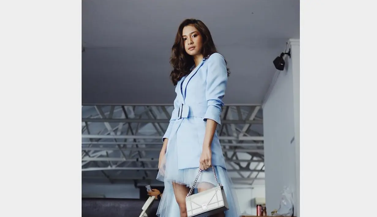 Mikha Tambayong tampil dalam balutan busana serba biru muda. Blazer dengan detail belt besar di bagian depan, dipadukannya dengan dress pendek berbahan organza yang dilapisi tulle untuk detail ekor yang menjuntai. Foto: Instagram.