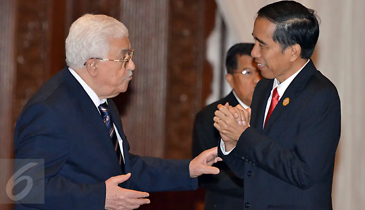 Ekspresi Presiden RI, Jokowi (kanan) saat berbincang dengan Presiden Palestina Mahmoud Abbas sesaat sebelum acara foto bersama peserta KTT Luar Biasa Organisasi Kerja sama Islam (OKI) di Jakarta Convention Center, Senin (7/3). (Liputan6.com/Faizal Fanani)