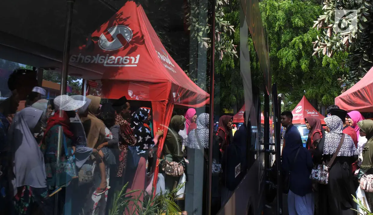 Antrean warga menaiki bus tingkat untuk wisata keliling Ibu Kota di depan Masjid Istiqlal, Jakarta, Sabtu (31/3). Sebanyak 22 armada bus tingkat City Tour Jakarta disiapkan melayani warga untuk berkeliling Jakarta secara gratis. (Merdeka.com/Imam Buhori)