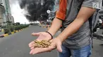Seorang warga menunjukkan peluru dari kendaraan Polisi yang terbakar di Jalan Brigjen Katamso, Slipi, Jakarta, Rabu (22/5/2019). Belum diketahui penyebab terbakarnya dua bus yang terparkir bersama bus polisi lainnya dilokasi tersebut. (merdeka.com/Arie Basuki)