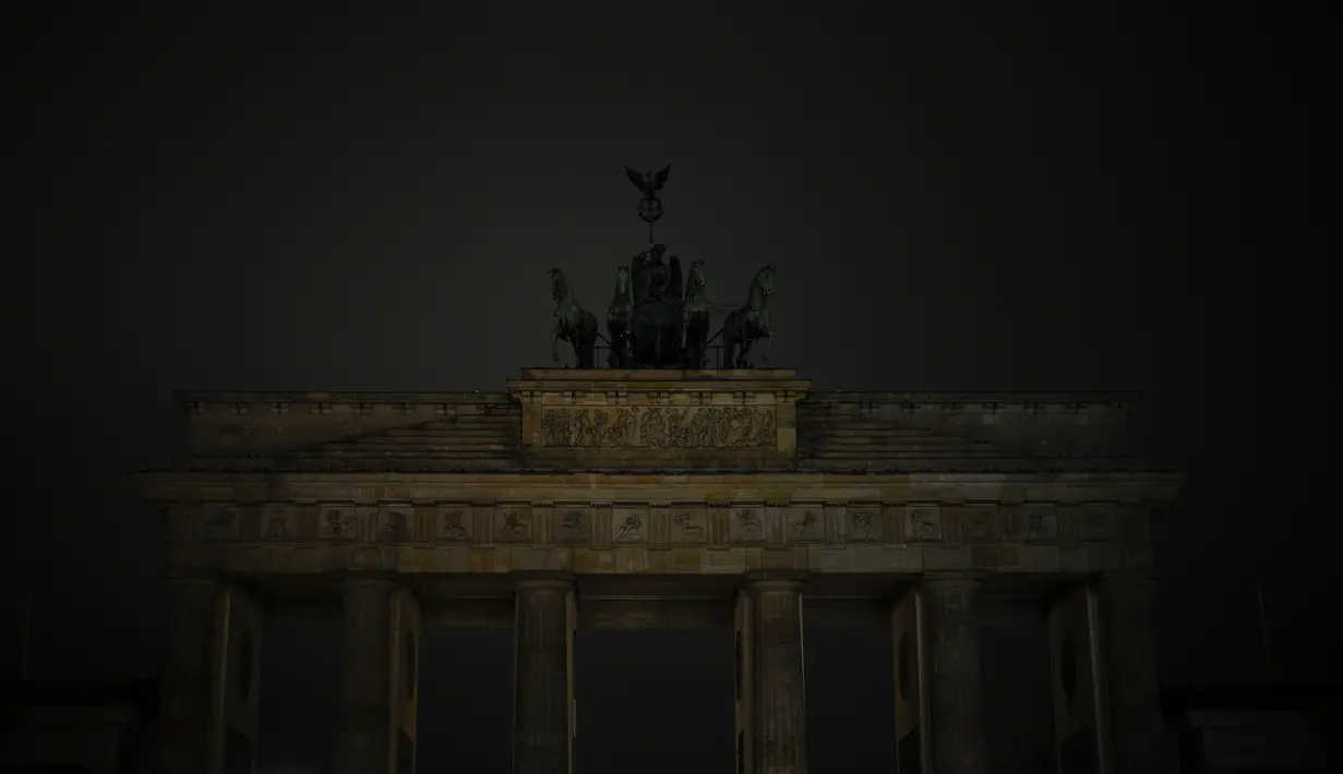 Lampu Gerbang Brandenburg terkenal Jerman dengan Quadriga di atasnya dimatikan untuk menandai Earth Hour di Berlin, Jerman, Sabtu, 25 Maret 2023. (AP Photo/Markus Schreiber)