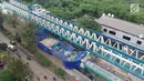 Suasana dari ketinggian konstruksi tiang beton Light Rail Transit (LRT) yang roboh di Kayu Putih, Jakarta Timur, Senin (22/1). Beton konstruksi LRT antarspan P28 dan P29 yang ambruk ditutupi terpal biru. (Liputan6.com/Arya Manggala)