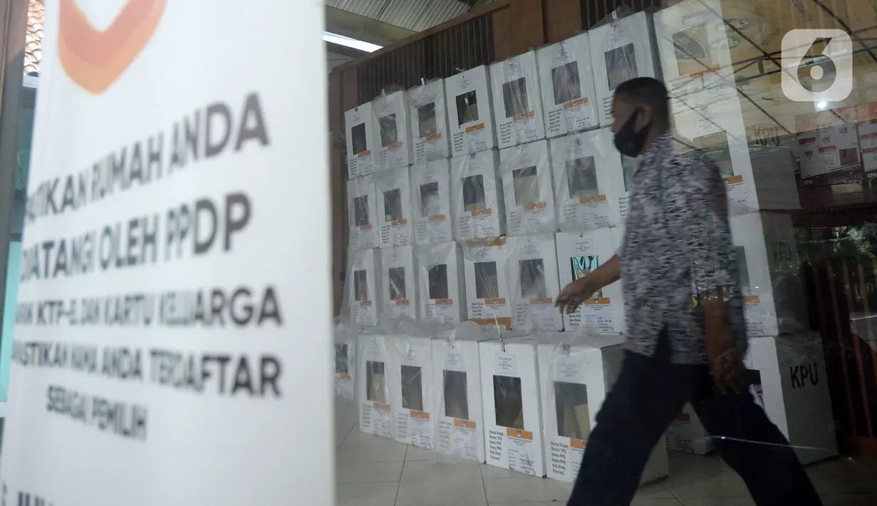 Seorang pria berjalan dekat kotak hasil rekapitulasi penghitungan suara di TPS tingkat kelurahan di Kecamatan Pamulang, Tangerang Selatan, Banten, Kamis (10/12/2020). Proses rekapitulasi suara ditunda sementara karena terkendala jaringan ke server KPU Pusat down. (merdeka.com/Dwi Narwoko)
