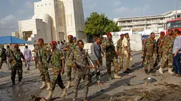 Sejumlah tentara mengamankan lokasi ledakan bom mobil yang terjadi dekat pos pemeriksaan parlemen dan Kementerian Dalam Negeri di Ibu Kota Somalia, Mogadishu, Minggu (25/3). Mobil meledak sebelum pasukan keamanan memeriksanya. (AP/Farah Abdi Warsameh)