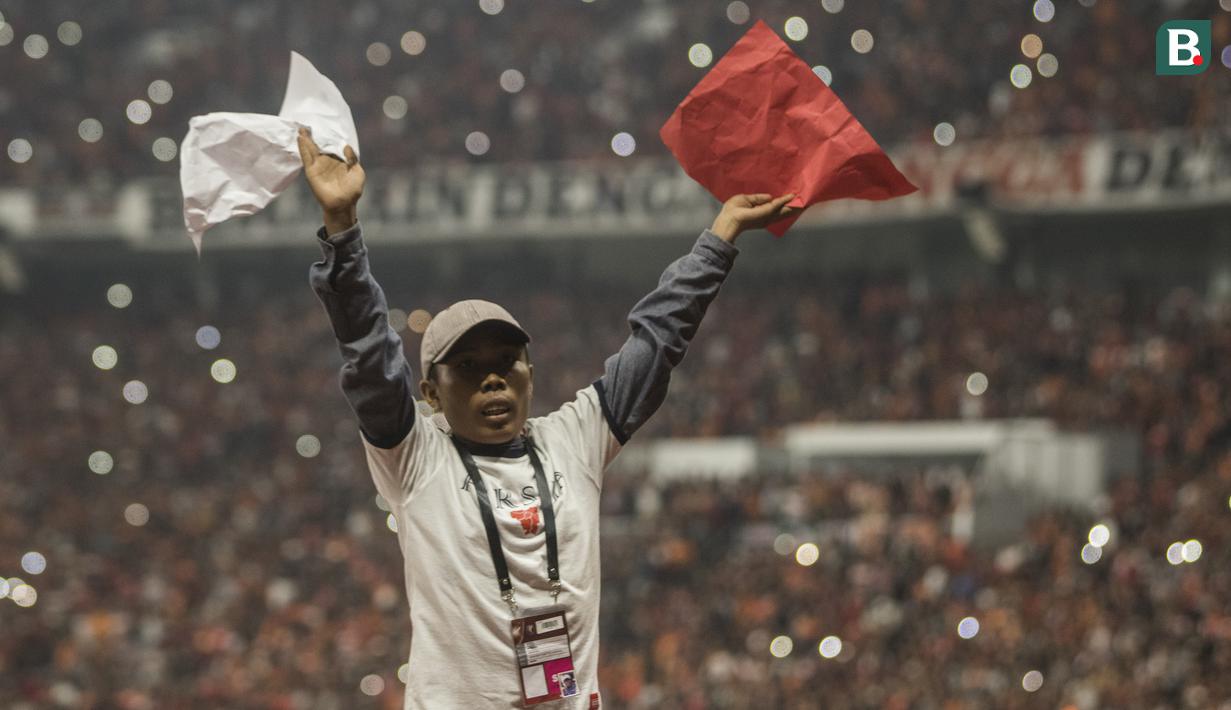 Seorang suporter Persija Jakarta, The Jakmania, memberikan aba-aba saat melawan Johor Darul Ta'zim pada laga Piala AFC di SUGBK, Jakarta, Selasa (10/4/2018). Persija menang 4-0 atas JDT. (Bola.com/Vitalis Yogi Trisna)