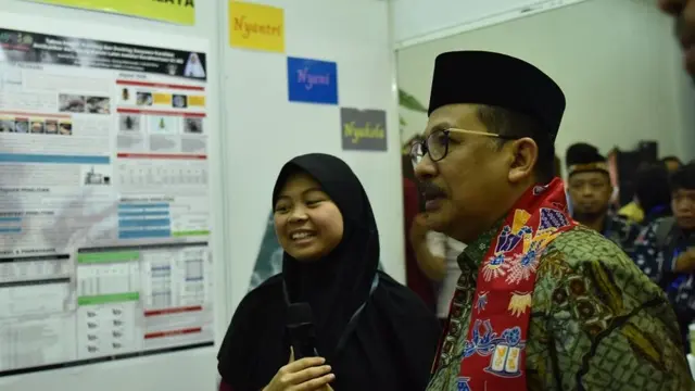 Nabilah Husniyah, siswa MAN Tasikmalaya, jelaskan hasil risetnya tentang potensi lalat sebagai antikanker ke Wamenag Zainut Tauhid. (Foto: kemenag.go.id/Liputan6.com)