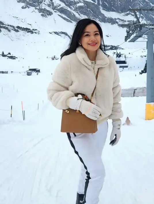 Titi Kamal tampil layaknya old money dengan gaya layering musim dinginnya. Titi menyatu dengan salju dengan busana serba putihnya mengenakan jaket hangat berbulu dipadukan celana putihnya.  [@titi_kamall]
