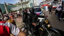 Sejumlah pasukan Brimob mengendarai motor dan bersenjata lengkap berpatroli saat Car Free Day di kawasan Bunderan HI, Jakarta, Minggu (24/12). (Liputan6.com/Faizal Fanani)