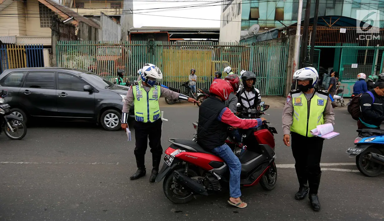 Petugas kepolisian memberhentikan pengendara motor saat Operasi Zebra Jaya 2017 di Daan Mogot, Jakarta, Selasa (7/11). Operasi Zebra yang digelar 1 November- 14 Desember 2017 tersebut secara serentak dilakukan se-Indonesia. (Liputan6.com/Johan Tallo)