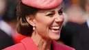 Kate Middleton, Duchess of Cambridge dari Inggris berbicara kepada para tamu di Pesta Taman Kerajaan di Istana Buckingham di London (18/5/2022). Kate Middleton mengenakan gaun mantel koral dengan topi dengan warna yang sama. (AFP/Pool/Dominic Lipinski)