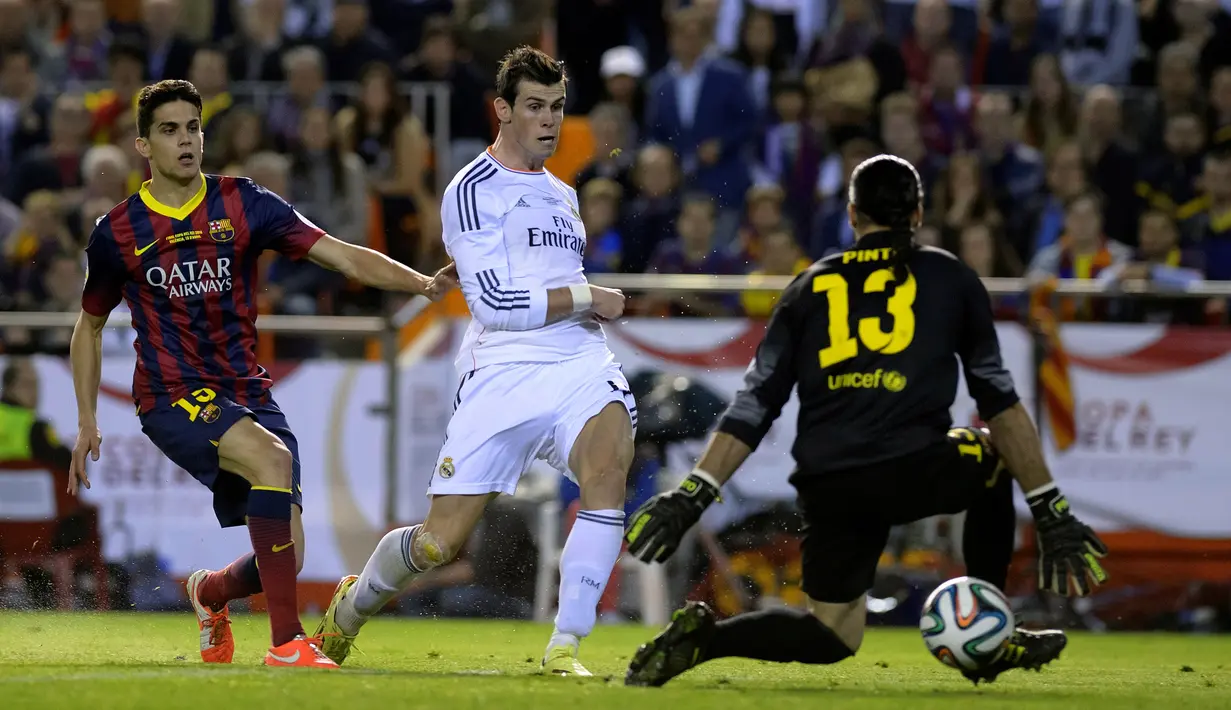 Gareth Bale memenangi sprint melawan Marc Bartra sebelum menaklukkan kiper Jose Manuel Pinto dalam final Copa del Rey di Stadion Mestalla, Valencia (16/4/2014). (AFP Photo/Dani Pozo)