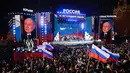Presiden Rusia dan kandidat presiden Vladimir Putin berpidato di hadapan pendukungnya dalam sebuah acara untuk memperingati 10 tahun aneksasi Rusia atas Krimea di Lapangan Merah, Moskow, 18 Maret 2024. (NATALIA KOLESNIKOVA/AFP)