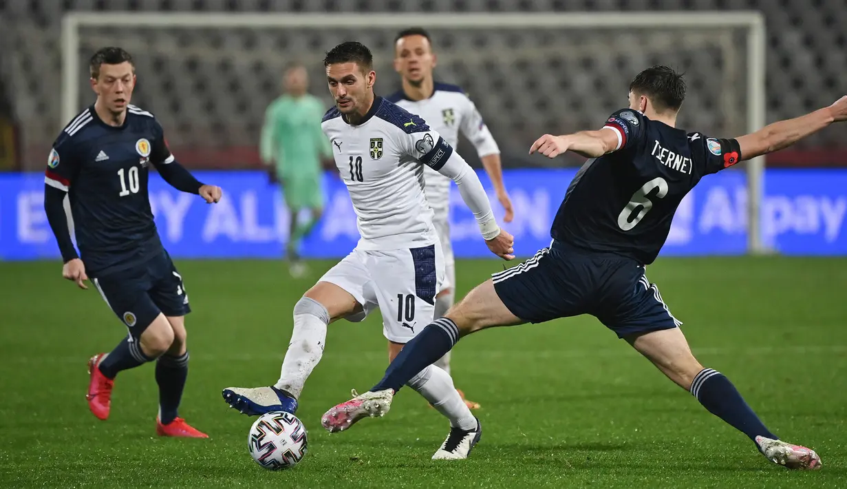 Gelandang Serbia, Dusan Tadic, berebut bola dengan gelandang Skotlandia, Callum McGregor, pada babak playoff Piala Eropa 2020 di Red Star Stadium, Jumat (13/11/2020) dini hari WIB. Skotlandia menang 5-4 atas Serbia lewat adu penalti. (AFP/Andrej Isakovic)