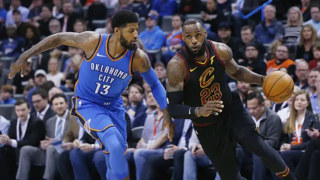 Paul George (biru) berduel dengan LeBron James