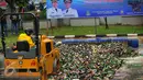 Sebuah alat berat dikerahkan untuk menghancurkan botol miras, Tangerang, Minggu (28/2/2016). Penghancuran miras dalam rangka HUT Kota Tangerang ke-23. (Liputan6.com/Faisal R Syam) 