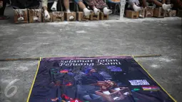 Poster mengenang meninggalnya peserta aksi semen kaki bernama Patmi (48), di depan Istana Merdeka, Jakarta, Rabu (22/3). Delapan aktivis menggelar aksi semen kaki untuk menghormati dan melanjutkan perjuangan Ibu Patmi (Liputan6.com/Faizal Fanani)