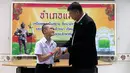 Salah seorang remaja, Mongkol Boonpiam menerima kartu identitas sebagai warga negara Thailand di distrik Mae Sai, Rabu (8/8). Korban gua Thailand tersebut selama ini hidup tanpa memiliki status kewarganegaraan (Chiang Rai Public Relations Office via AP)
