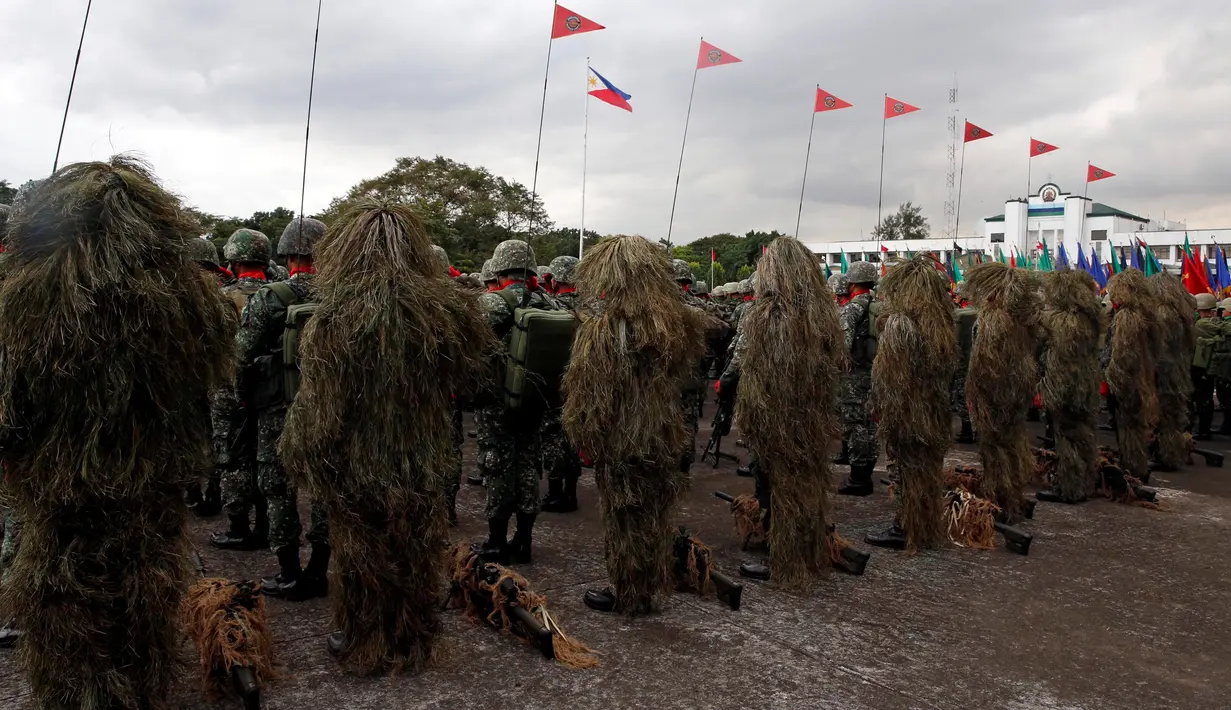 Barisan tentara penembak jitu yang mengenakan pakaian kamuflase saat upacara pergantian Kepala Angkatan Bersenjata di kamp militer di Kota Quezon, Manila, Filipina (7/12). Tentara ini melakukan penyamaran dari kejauhan. (Reuters/Erik De Castro)